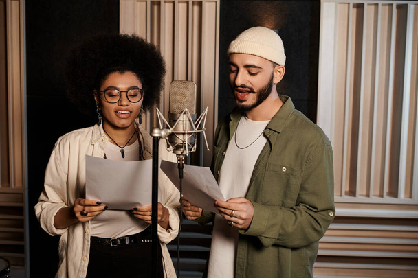 Un uomo e una donna si armonizzano mentre cantano in uno studio di registrazione durante le prove della banda musicale. - Foto, immagini