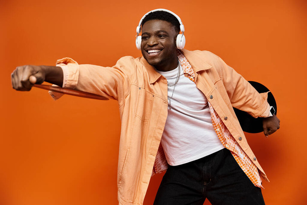 Joven hombre afroamericano en chaqueta de moda y auriculares posando para una foto. - Foto, Imagen