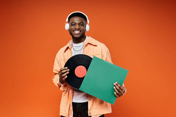 A fashionable young African American man holds a vinyl record. - Photo, Image