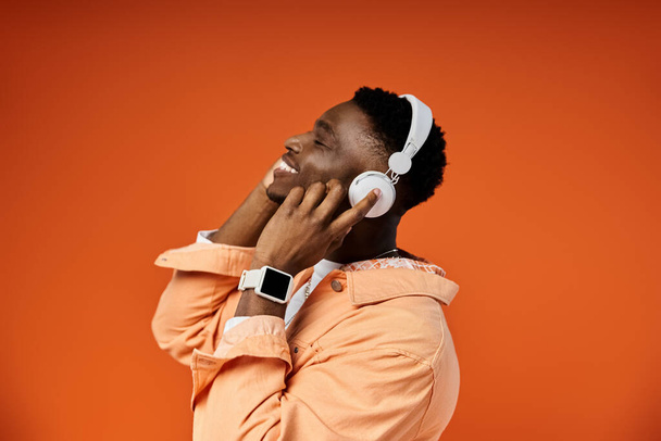 Νεαρό Αφρικής αρσενικό απολαμβάνει τη μουσική με ακουστικά. - Φωτογραφία, εικόνα