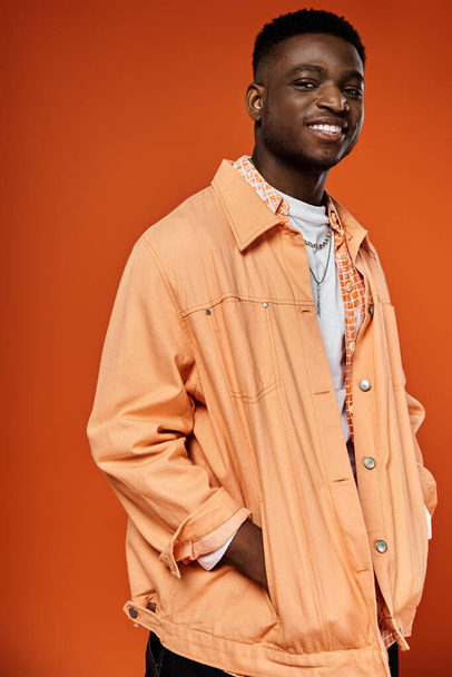 Handsome man in orange jacket striking a pose for camera - Photo, Image