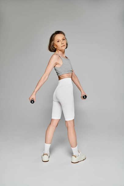 Aktív nő bemutató erejét súlyzókkal. - Fotó, kép