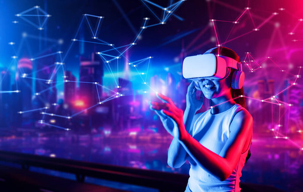 Smart female standing in cyberpunk style building in meta wear VR headset connecting metaverse, future cyberspace community technology, woman use indexfinger touch virtual object. Halluzination. - Foto, Bild