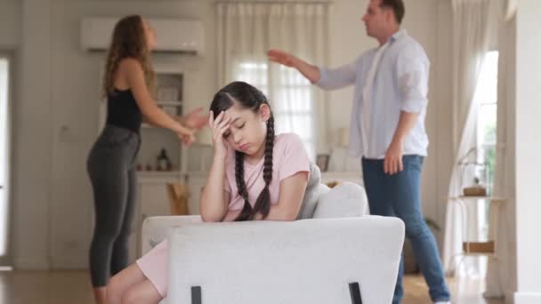 Dühös és boldogtalan fiatal lány ül a kanapén csapdába a feszültség közepén a szülői vita a nappaliban. Egészségtelen otthoni életmód és traumás gyermekkor alakul depresszió Kényes - Felvétel, videó
