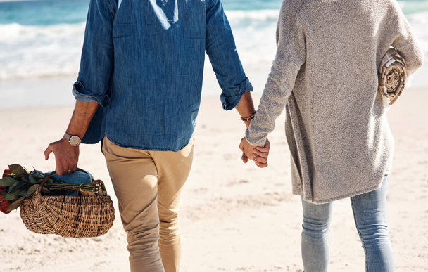 Paar, Strand und Händchen halten oder im Urlaub am Meer oder Meer mit Liebe spazieren gehen. Sommer, Reise und Picknickkorb auf der Insel mit Menschen, die sich bei einem Outdoor-Date mit Sorgfalt vermählen. - Foto, Bild