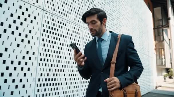 Business man answer phone call and talking about business investment. Happy manager walking at street while talking on smart phone to discuss business plan or marketing strategy or working. Exultant. - Footage, Video