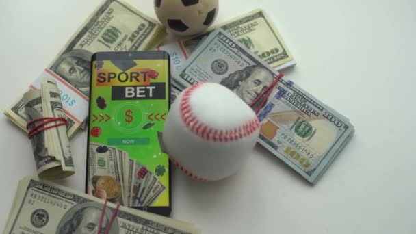 Smartphone with gambling mobile application and soccer ball with money close-up. Sport and betting concept. High quality photo - Footage, Video