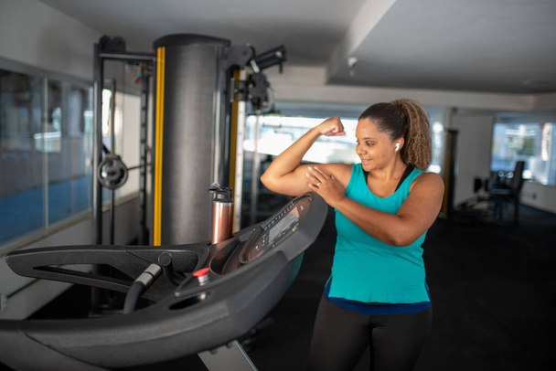 Sportliche Frau, die im Fitnessstudio an mehreren Stationen trainiert. Fitnesstraining im Fitnessstudio - Foto, Bild