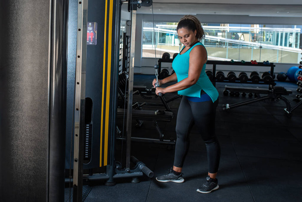 Sporty žena cvičení na multistation v tělocvičně. Fitness cvičení v posilovně - Fotografie, Obrázek