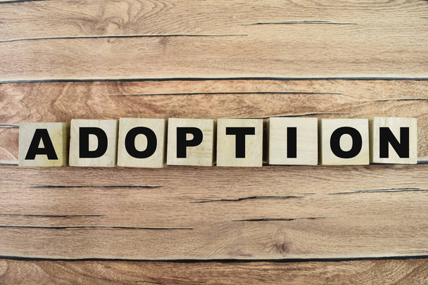 Concept of The wooden Cubes with the word Adoption on wooden background. - Photo, Image
