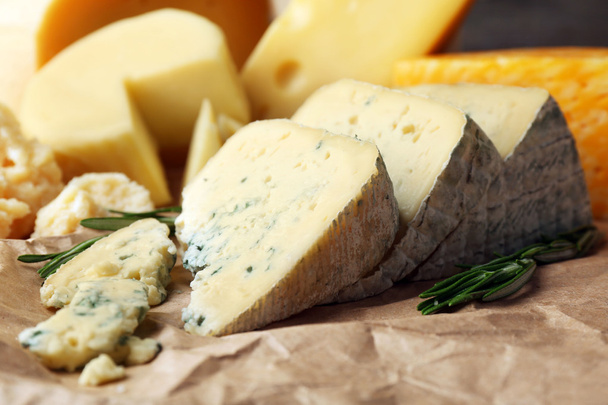 Various types of cheese with rosemary on table close up - Foto, Imagem