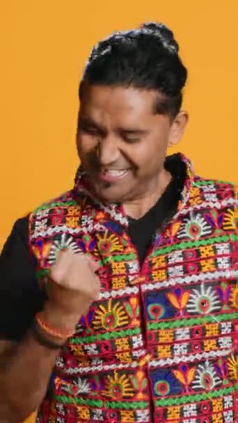Video verticale Ritratto di narcisista allegro indiano che festeggia e si vanta, mostrando arroganza. Persona soddisfatta che vanta di successo, applausi e gesticolazioni, background in studio - Filmati, video