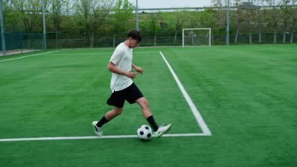 Joueur de football adolescent court le long du terrain de football. - Séquence, vidéo