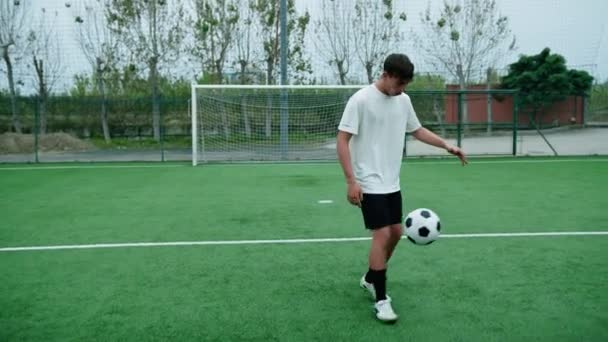 Genç futbolcu futbol topuyla top sürüyor.. - Video, Çekim