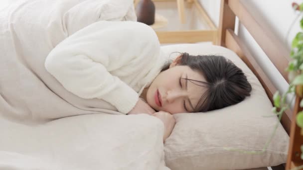 Una donna che misura la sua temperatura con un termometro mentre dorme - Filmati, video
