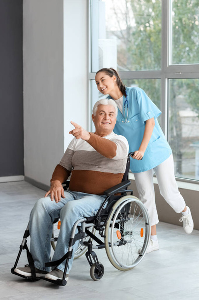 Hombre mayor en silla de ruedas y enfermera en el hospital - Foto, imagen
