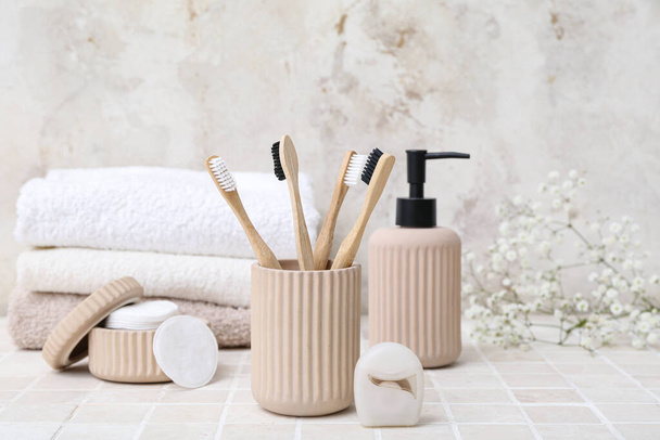 Set of bath supplies with bamboo toothbrushes on light tile table - Photo, Image