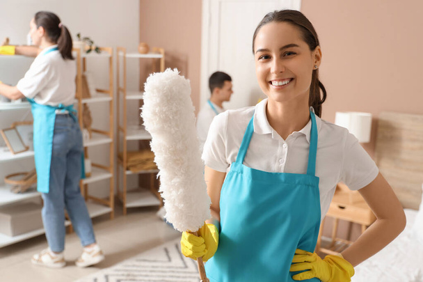 Γυναίκα υπάλληλος καθαριότητας με pp-duster στο υπνοδωμάτιο - Φωτογραφία, εικόνα