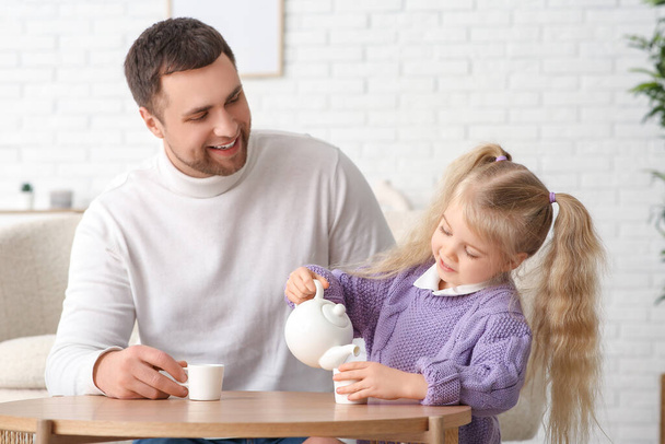 Счастливый отец со своей милой маленькой дочкой, чаепитие дома - Фото, изображение