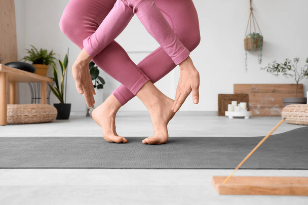 Giovane donna sportiva che fa yoga su tappetino in palestra, primo piano - Foto, immagini