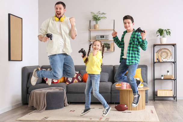 Щасливий батько і його маленькі діти з ігровими майданчиками стрибають вдома - Фото, зображення