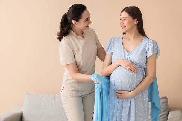 Doula balení těhotné ženy s šátkem doma - Fotografie, Obrázek