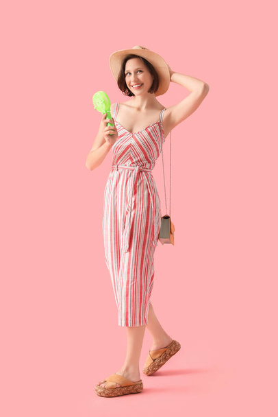 Junge Frau mit grünem Mini-Ventilator auf rosa Hintergrund - Foto, Bild