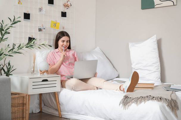 Nainen opiskelija opiskelee kannettava sängyllä kotona - Valokuva, kuva