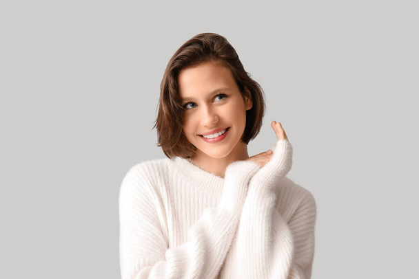 Onnellinen nuori nainen tyylikäs valkoinen pusero harmaalla taustalla - Valokuva, kuva