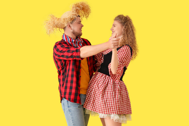 Glückliches junges Paar tanzt auf gelbem Hintergrund. Festa Junina - Foto, Bild