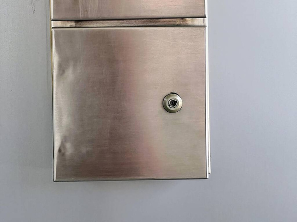 uma fotografia de uma caixa de correio de metal com uma fechadura na parede. - Foto, Imagem