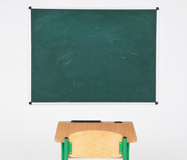 Чорна дошка і дерев'яний стіл зі стільцем в класі
 - Фото, зображення