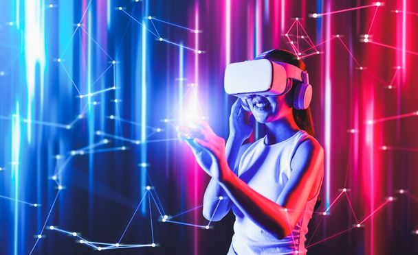 Smart female standing in cyberpunk style building in meta wear VR headset connecting metaverse, future cyberspace community technology, woman use finger touch virtual reality object. Halluzination. - Foto, Bild