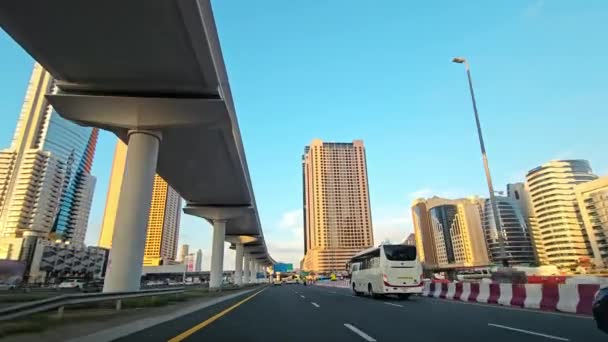 Dynamic Urban Highway Scene with Modern Skyscrapers, Θέα από αυτοκινητόδρομο σε πολυσύχναστη πόλη με σύγχρονους ουρανοξύστες και υποδομές σε μια ηλιόλουστη μέρα - Πλάνα, βίντεο