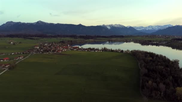 Der Riegsee in Oberbayern bei Sonnenuntergang. Aerial view Riegsee Lake near Murnau, Bavaria, Germany, Europe. Ammergauer Alpen in background at sunset in spring. Tourismusregion Das Blaue Land.  - Footage, Video