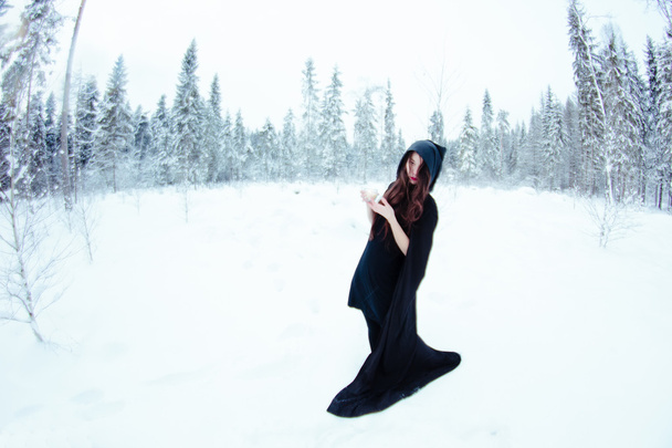Schöne Hexe in schwarzem Mantel mit magischem Ball - Foto, Bild