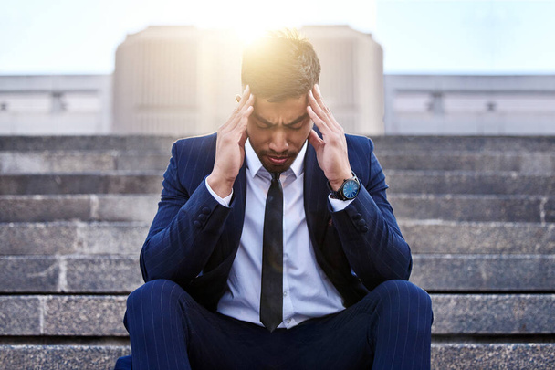 Stress, Geschäftsleute und Menschen mit Kopfschmerzen auf Treppen wegen Burnout, Angstzuständen und Migräne durch Arbeitsdruck. Frustrierte, professionelle und männliche Person auf Stufen, müde und verschuldet mit Projekttermin. - Foto, Bild