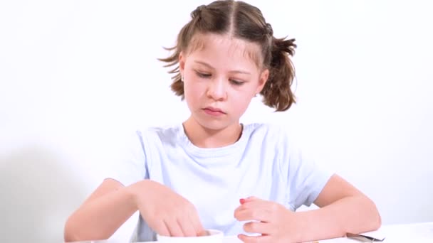 Junges Mädchen, das sich zutiefst mit der Kunst der Armbandherstellung beschäftigte und lebendige Tonperlen zu einzigartigen Mustern auffädelte. Ihr Arbeitsplatz ist fein säuberlich mit verschiedenen Perlen arrangiert, die ihr Engagement in der - Filmmaterial, Video