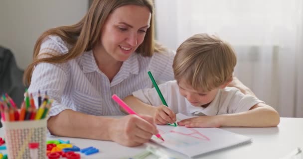 Renkli kalemlerle çizen kadın ve genç çocuk. Eğitici konseptle samimi bir aile anı. Yüksek kalite 4k görüntü - Video, Çekim
