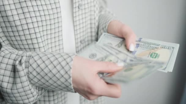 Un primo piano di un uomo d'affari mani contando banconote in dollari, che simboleggia il concetto di gestione della ricchezza e meticolosa pianificazione finanziaria - Filmati, video