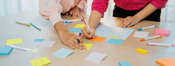 Groep van jonge business groep brainstormen ideeën over kleurrijke plakkerige notities. Een portret van startup group planing marketing strategie terwijl het opschrijven van op plakkerige nota op kantoor vergaderzaal. Afgerond. - Foto, afbeelding