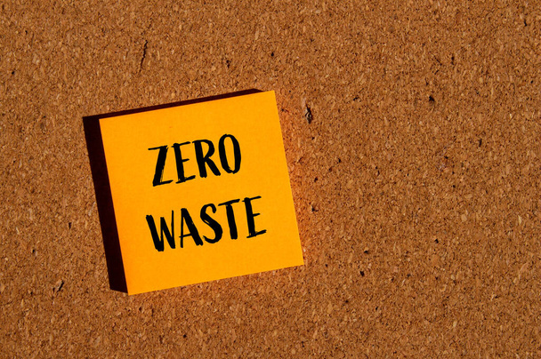 Zero odpadów słowa napisane na pomarańczowym papierze naklejki z brązowym tle. Koncepcyjny symbol zero odpadów. Przestrzeń kopiowania. - Zdjęcie, obraz