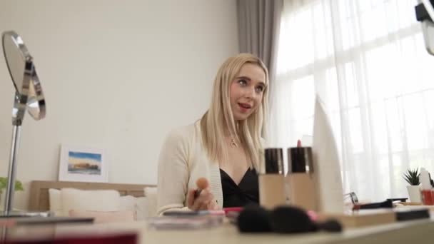 Young woman making beauty and cosmetic tutorial video content for social media. Beauty blogger smiles to camera while showing how to beauty care to audience or followers. Blithe - Footage, Video