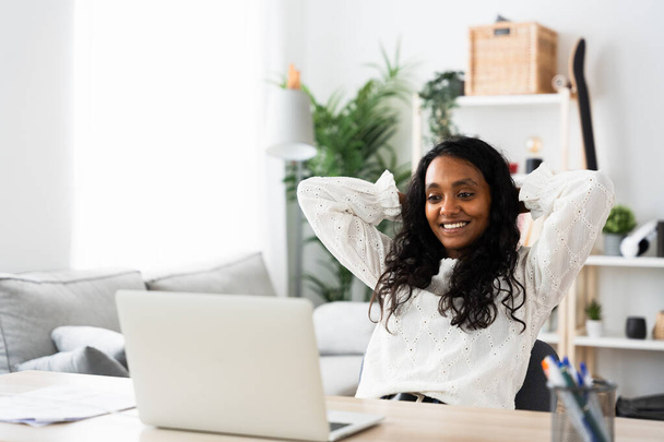 Indiase vrouw ontspannen in de voorkant van de laptop. Jonge ondernemer werkt vanuit huis. - Foto, afbeelding