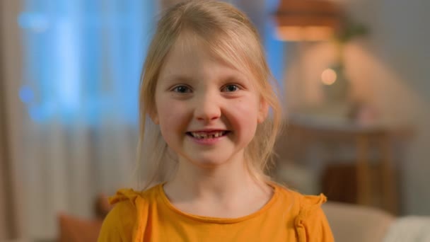 Portrait little Caucasian girl child daughter schoolgirl happy joyful toothy smiling female pupil school kid orphan carefree funny toddler baby face purity smile laugh home children custody adoption - Imágenes, Vídeo