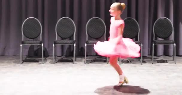dziewczyna w różowej sukni balowej przędzenie na podłodze. - Materiał filmowy, wideo