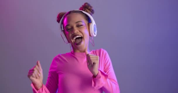 Woman, dancing and neon light with headphones in studio or streaming entertainment or music, playlist or listening. Female person, happy and purple background or techno audio radio, glitter or mockup. - Footage, Video