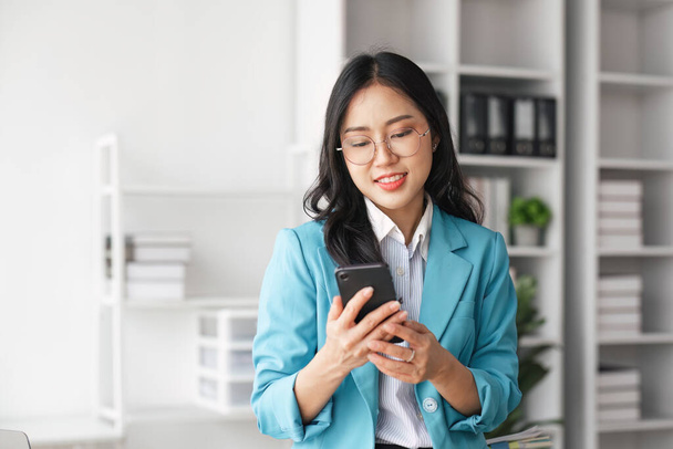 Geschäftsfrau tippt mit Handy in Firma ein Gespräch im Internet. - Foto, Bild