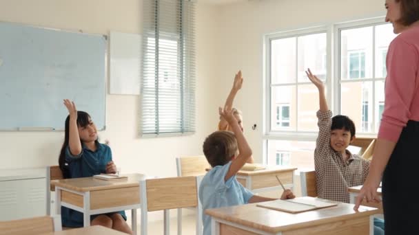 Zróżnicowany mądry uczeń podniósł ręce, aby odpowiedzieć na pytania w klasie podczas nauki i słuchania szczęśliwy nauczyciel. Wielokulturowe dzieci podnoszą ręce pod wolontariat, głosowanie, zadawanie pytań. Pedagogika. - Materiał filmowy, wideo