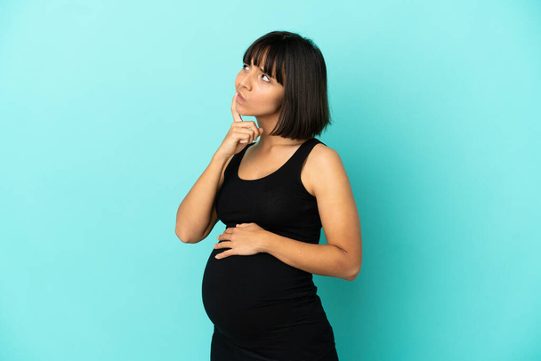 Frau mit isoliertem Hintergrund schwanger und denkend - Foto, Bild